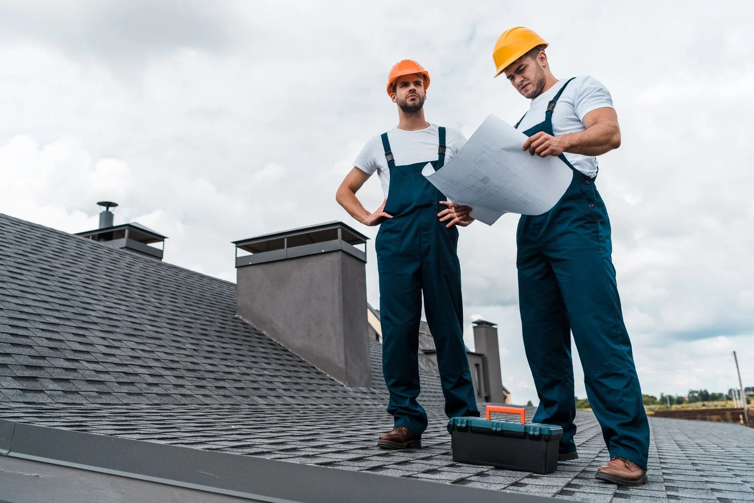 Two architects tanding on top of a roof doing an inspection