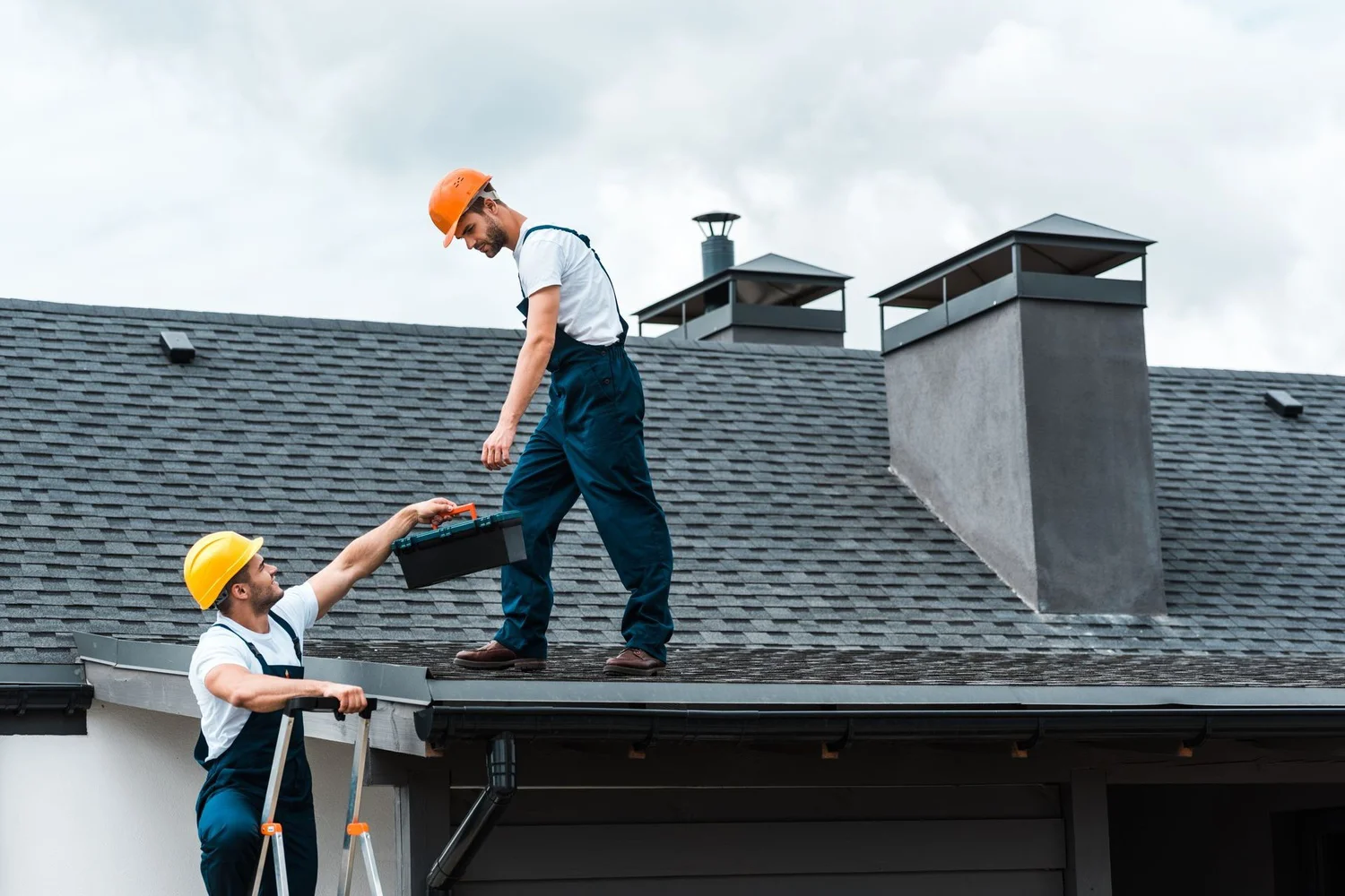 Roofing maintenance crew working together repairing a roof